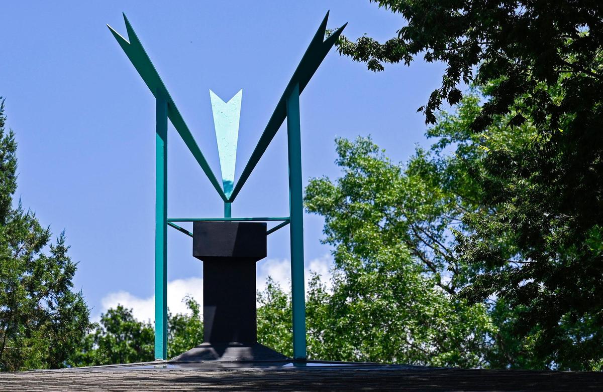 A turquoise-colored metal sculpture adorns the roof of the Searing House.