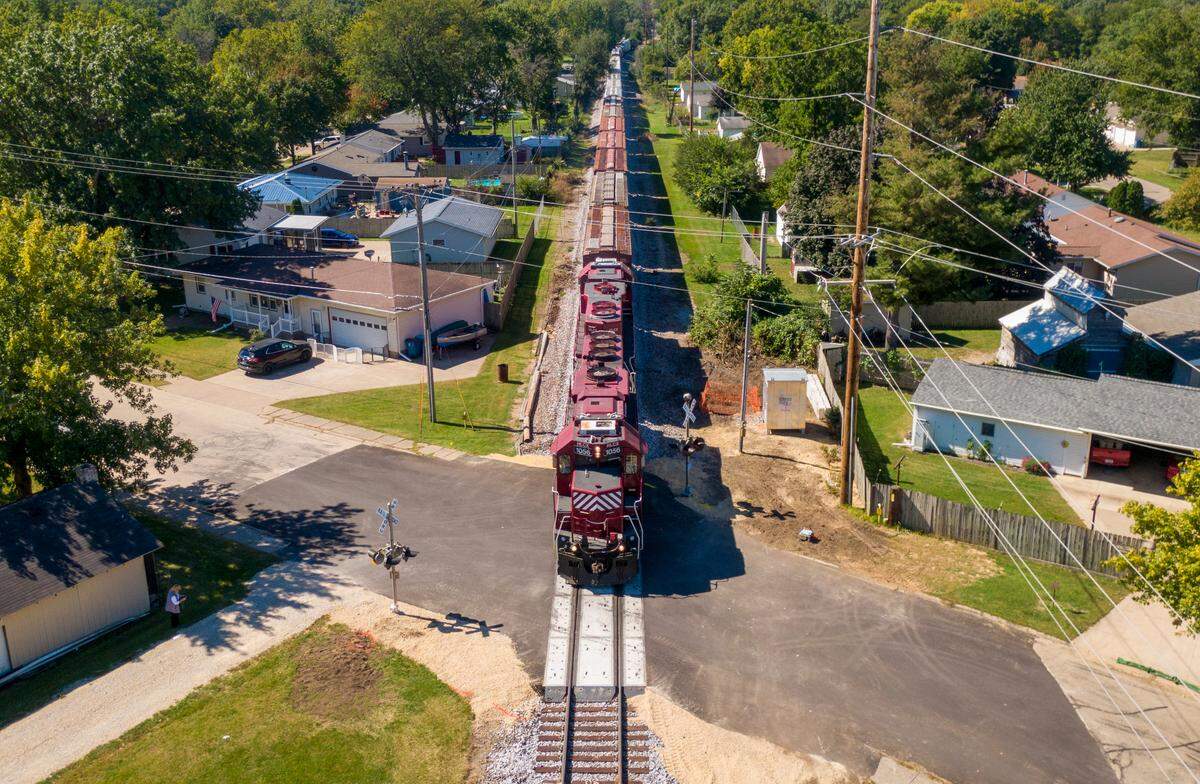 A Canadian Pacific freight train rolls through one of seven railroad crossings on Wednesday, Sept. 28, 2022, in Camanche, Iowa. A merger of Kansas City Southern and Canadian Pacific railways will increase train traffic and length of trains traveling through the town, potential blocking rail crossing for extended periods of time.