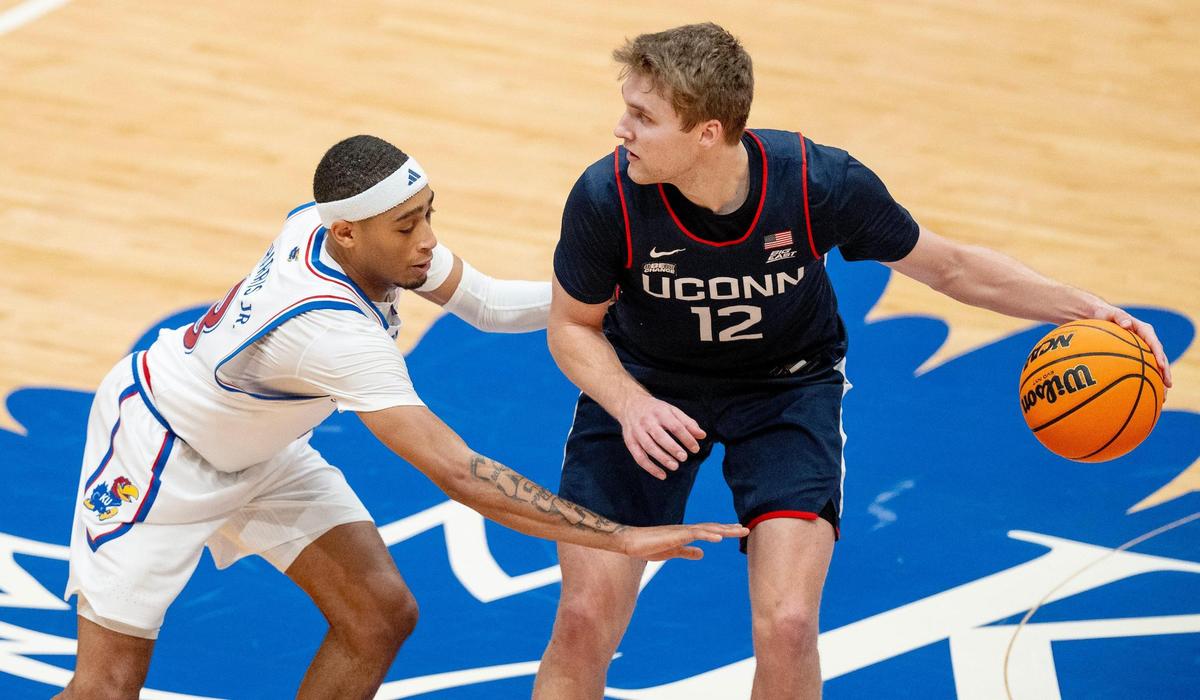 Kansas Jayhawks guard Dajuan Harris Jr. (3) guards Connecticut Huskies guard Cam Spencer (12) during an NCAA basketball game on Friday, Dec. 1, 2023, in Lawrence, Kan.