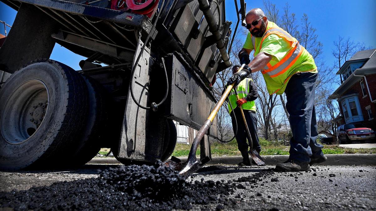 Jason Brown, an equipment operator for Kansas City Public Works, fills a pothole recently with piping hot asphalt on Benton Boulevard, near 25th Street on Kansas City’s east side.