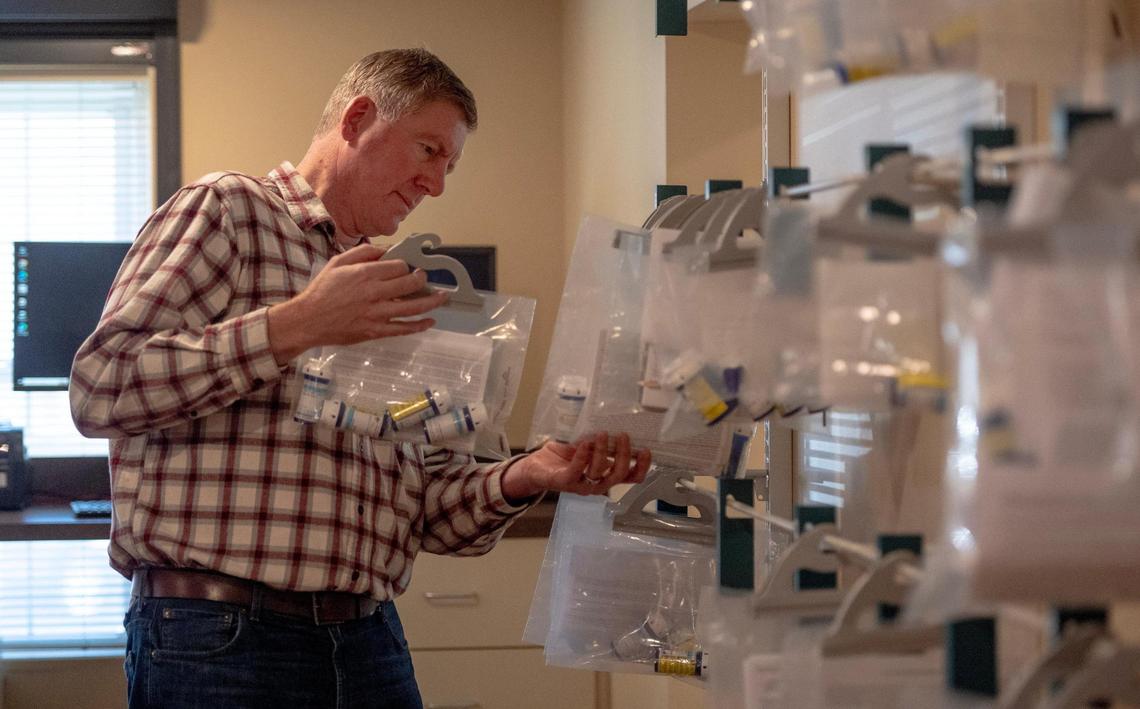 Pharmacist-in-charge Michael Fink hangs a prescription ready for pickup.  Though the pharmacy is in Wyandotte County, anyone in the metro, even from Missouri, can use it.