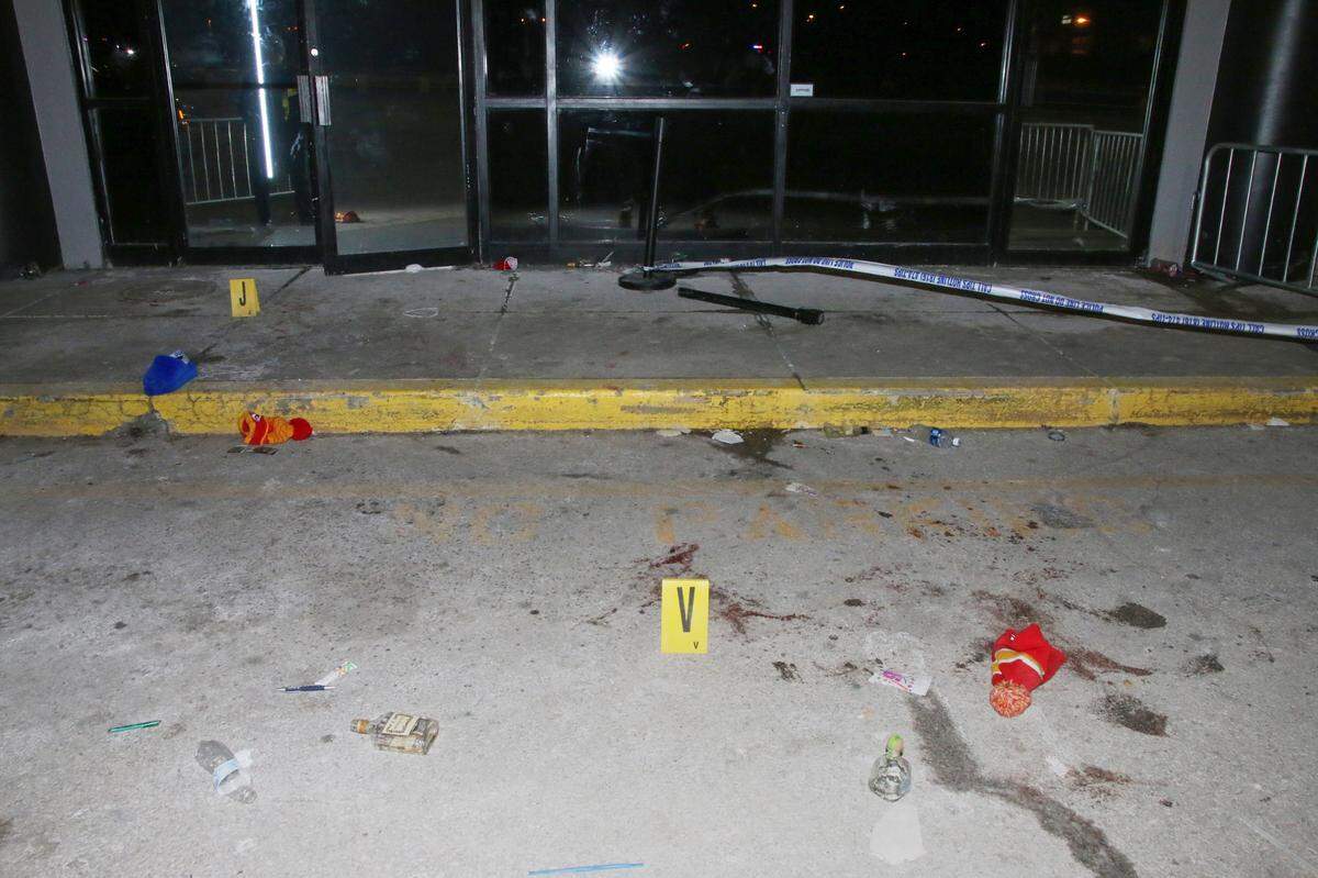 A police evidence photo from outside the 9ine Ultra Lounge shows yellow evidence markers amid stocking caps and liquor bottles after a mass shooting there in January 2020