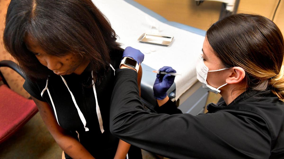 Breana Slusser, a medical assistant at Family Health Care KC, gave Amijah Parker, 16, of Kansas City, her COVID-19 vaccination booster in January at the clinic in Kansas City, Kansas.
