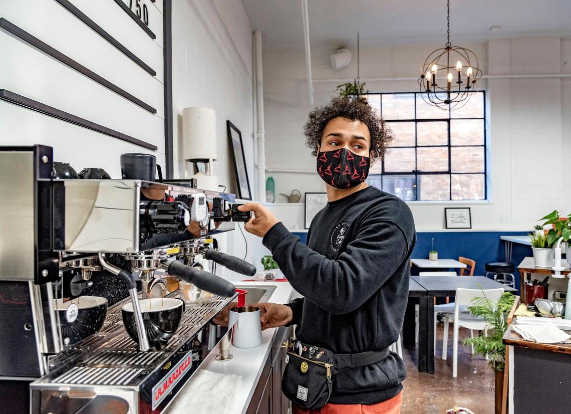 Kinship Cafe owner T.J. Roberts brews coffee for a customer.