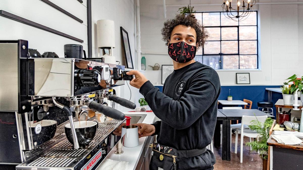Kinship Cafe owner T.J. Roberts brews coffee for a customer. He started his Kansas City small business during the pandemic, and worked with G.I.F.T. to make it happen.