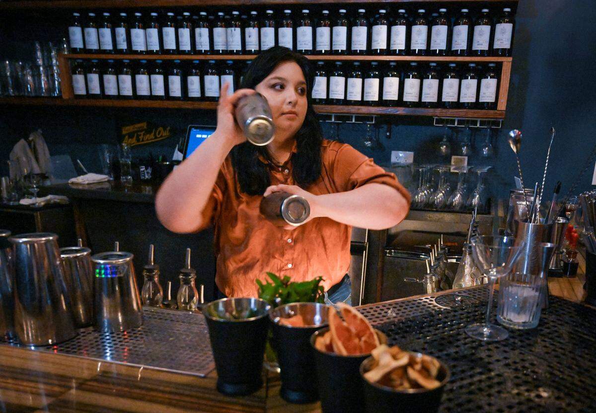 Bartender Sage Monet shakes two drinks at Drastic Measures, a small, cocktails-only bar in downtown Shawnee.