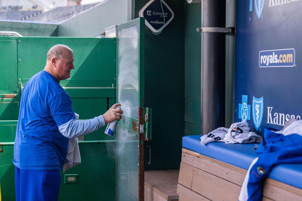 Paul Brack, a retired volunteer that has worked for the Royals for the last 12 years, sprays window cleaner on glass in the Royals dugout at Kauffman Stadium on Tuesday, March 25, 2025. Brack said he could think of a better retirement job.