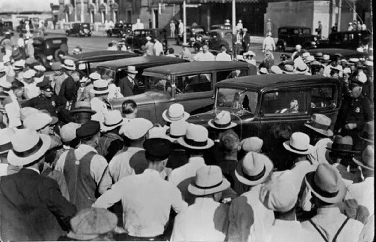 Onlookers gather around cars that were shot at during the Union Station massacre in 1933.