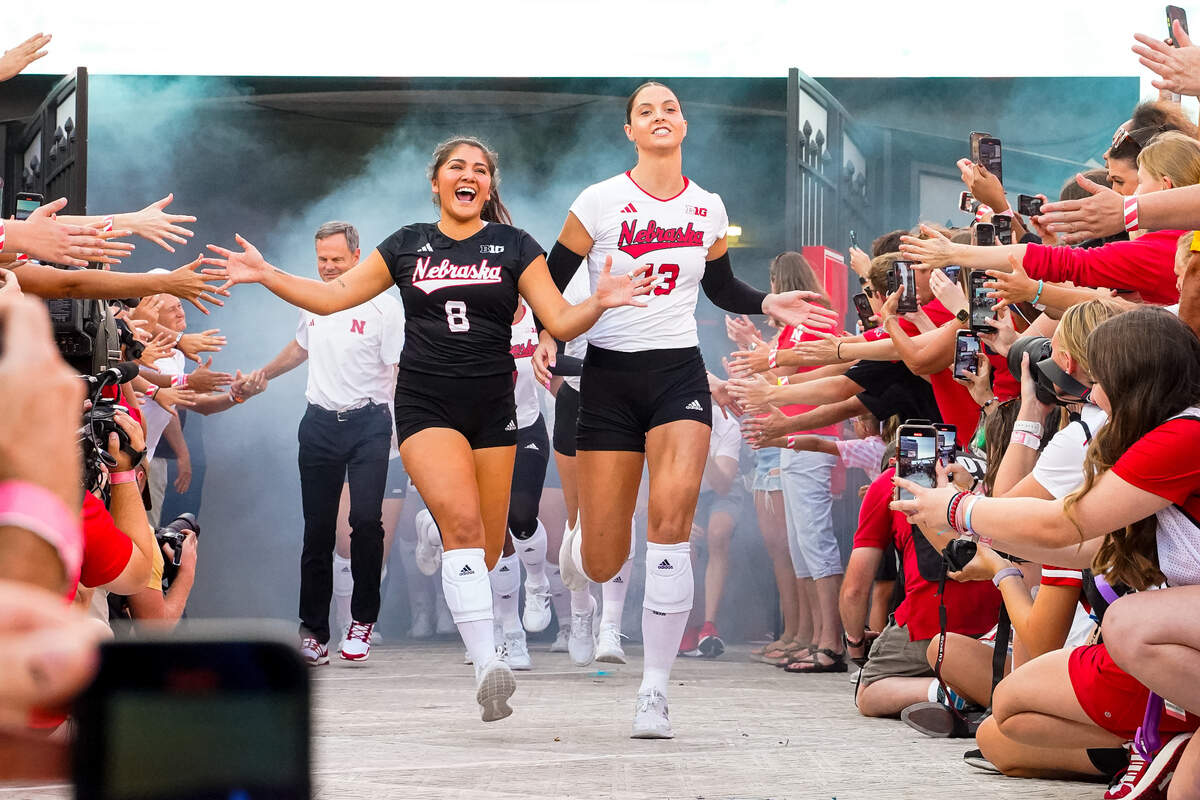 Nebraska Cornhuskers outside hitter Merritt Beason (13) and libero Lexi Rodriguez (8) run out of the tunnel before the match against the Omaha Mavericks at Memorial Stadium.