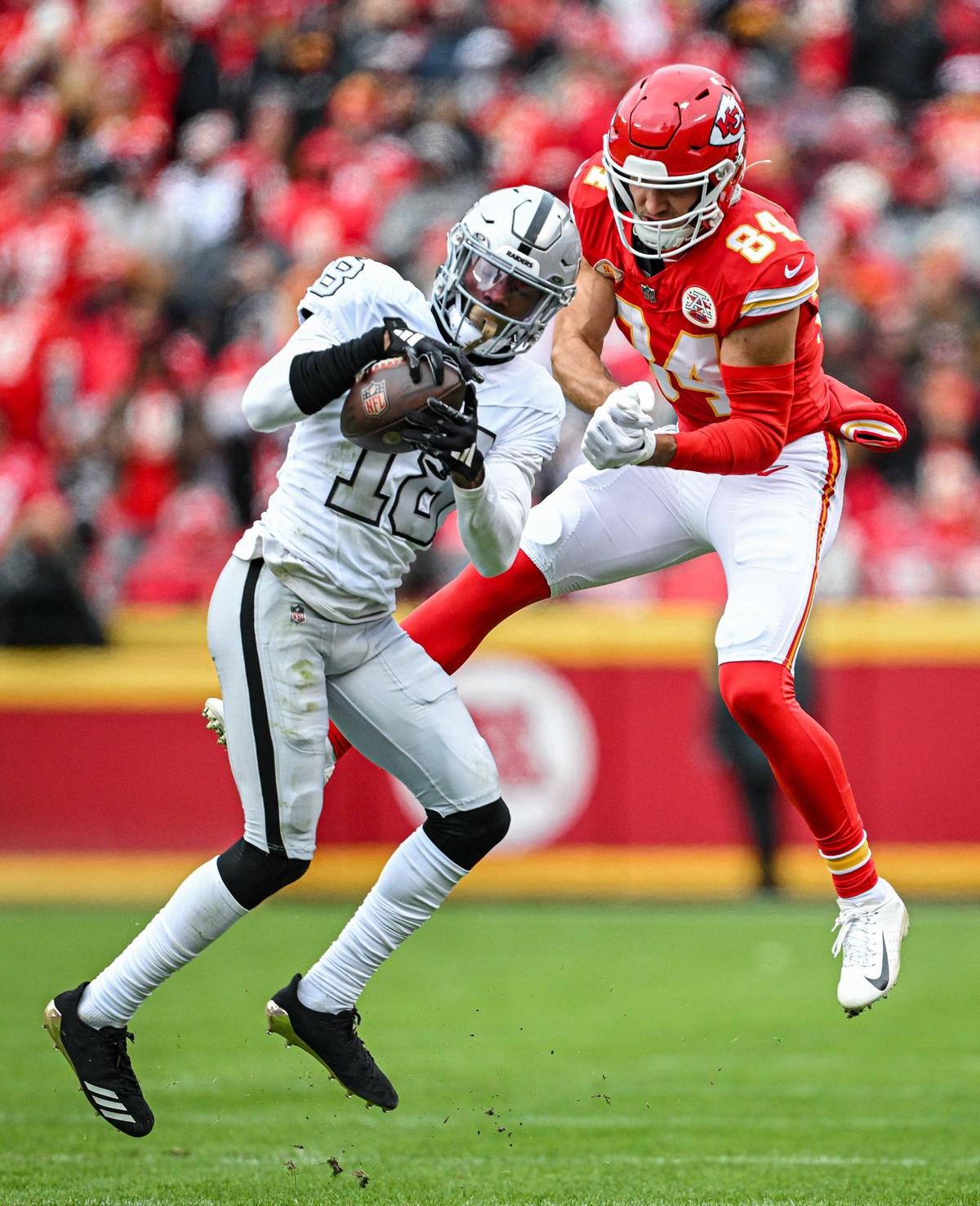 Las Vegas Raiders cornerback Jack Jones (18) picked off a pass intended for Kansas City Chiefs wide receiver Justin Watson (84) and ran it in for a touchdown in the second quarter Monday, Dec. 25, 2023, at GEHA Field at Arrowhead Stadium.
