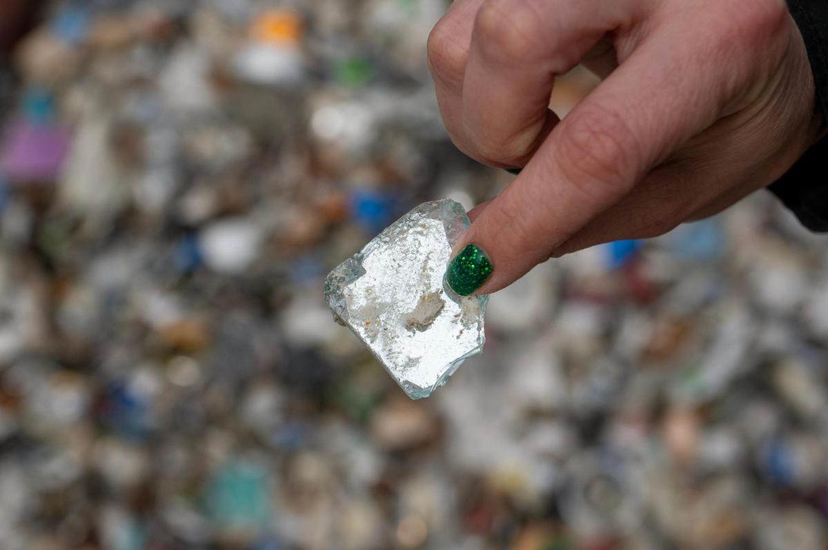 Director of sustainability and strategic analysis Lydia Gibson shows a piece of a broken mirror at the Ripple Glass processing facility on Wednesday, March 15, 2023, in Kansas City. Materials like ceramic, porcelain or mirrors are not accepted at Ripple Glass.