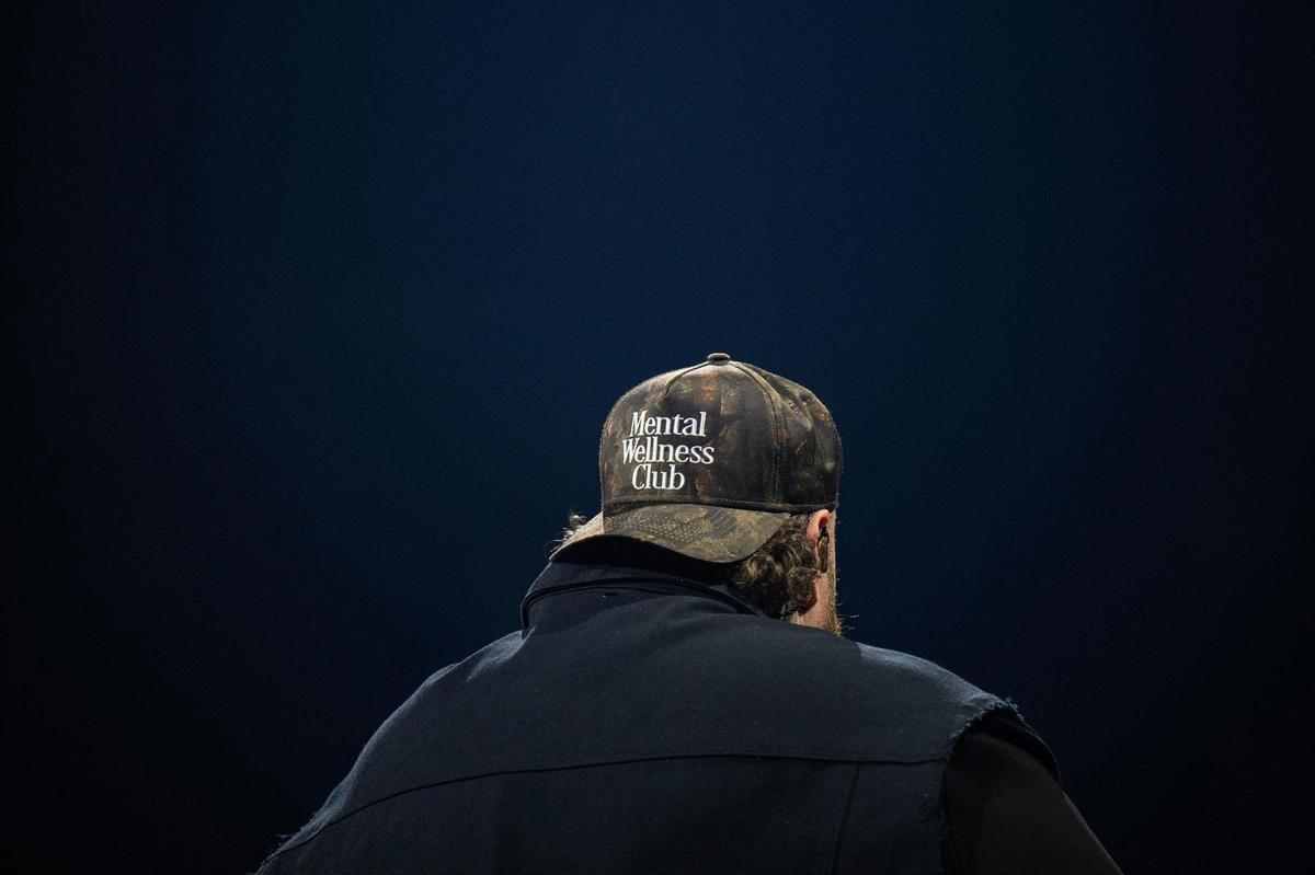 Jelly Roll wears a hat reading “Mental Wellness Club” while performing the song “I Am Not Okay” on Wednesday. Mental health and overcoming personal struggles were a theme of his show.