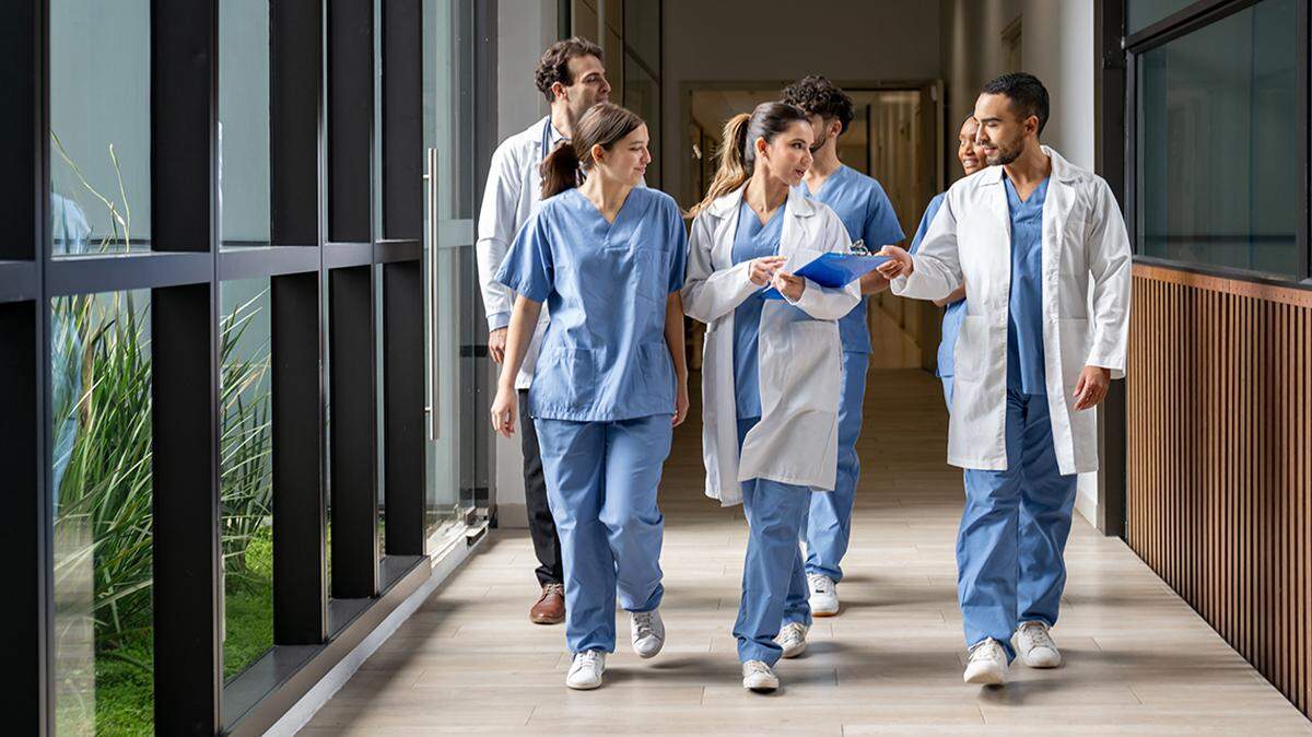 Happy group of medical students walking in the corridor at the hospital while talking