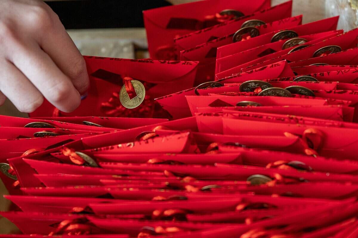 A stack of lucky red envelopes sit in a box as they are handed out to guests during a Lunar New Year celebration at the Lenexa Public Market on Sunday, Feb. 22, 2026, in Lenexa.