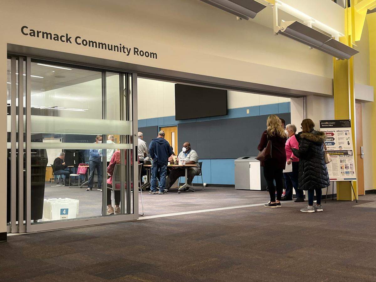 Voters wait in line to vote Tuesday at the Johnson County Central Resource Library in Overland Park. 