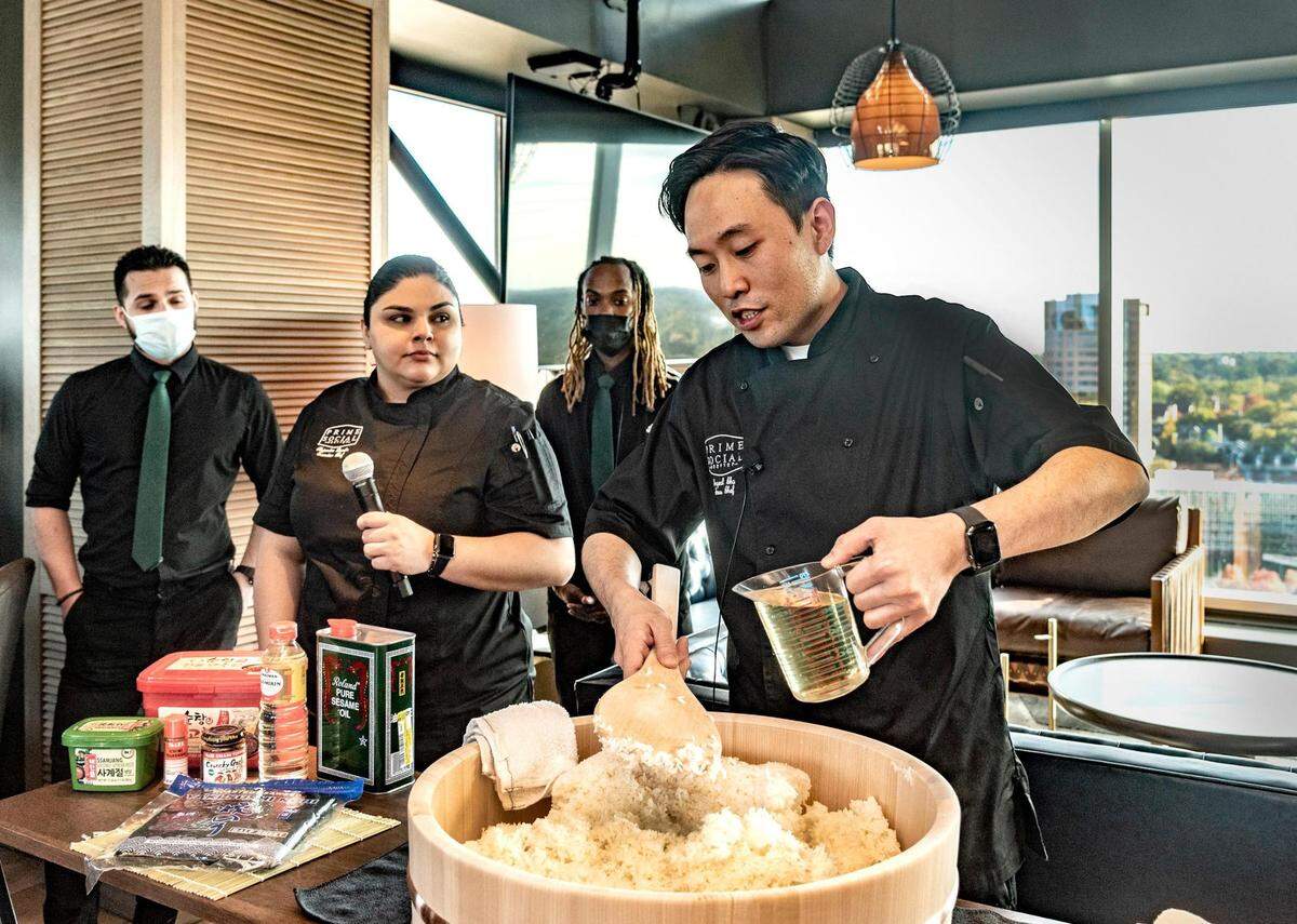 Sous chef Ingeol Cho, right, demonstrated proper sushi rice preparation for the staff at Prime Social. In addition to sushi rolls, menu items will include lobster tails, pork belly burnt ends and a 16-ounce KC strip.