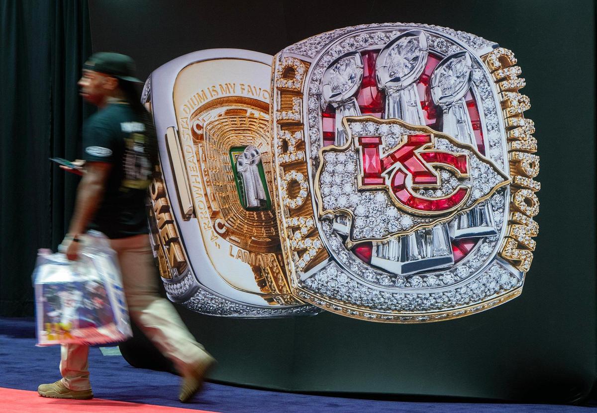 A Philadelphia Eagles fan walks past an oversized display of the Chiefs Super Bowl LVIII ring during a visit to the Super Bowl Experience at the Ernest N. Morial Convention Center on Thursday, Feb. 6, 2025, in New Orleans.