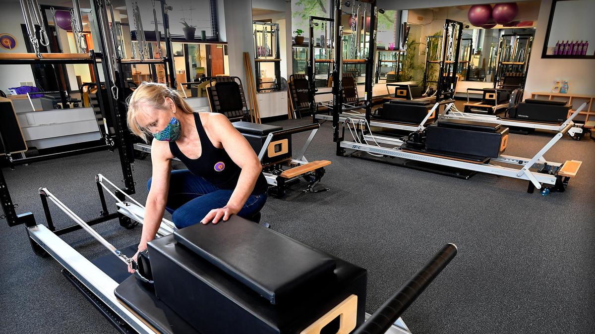 In preparation of reopening her business after the initial COVID-19 shutdown in 2020, Lisa Looy, master trainer at Pilates 1901, in Kansas City, checks and cleans equipment.