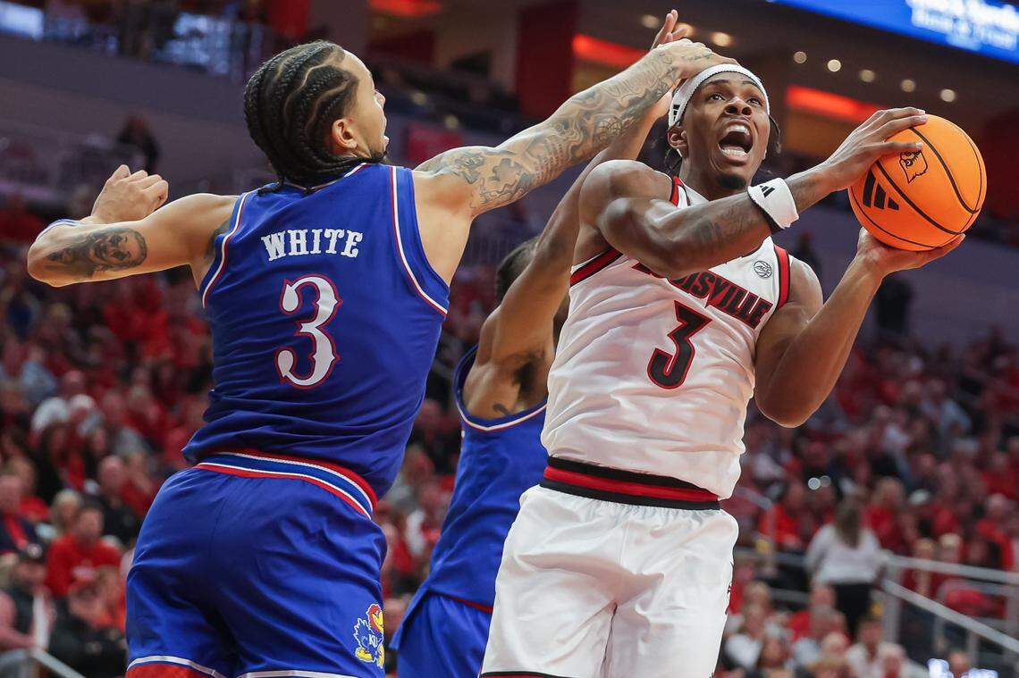 Kansas Jayhawks guard Tre White gets a hand in the face of Ryan Conwell of the Louisville Cardinals during a men’s college basketball exhibition game at the KFC Yum! Center in Louisville, Kentucky on Friday, October 24, 2025.
