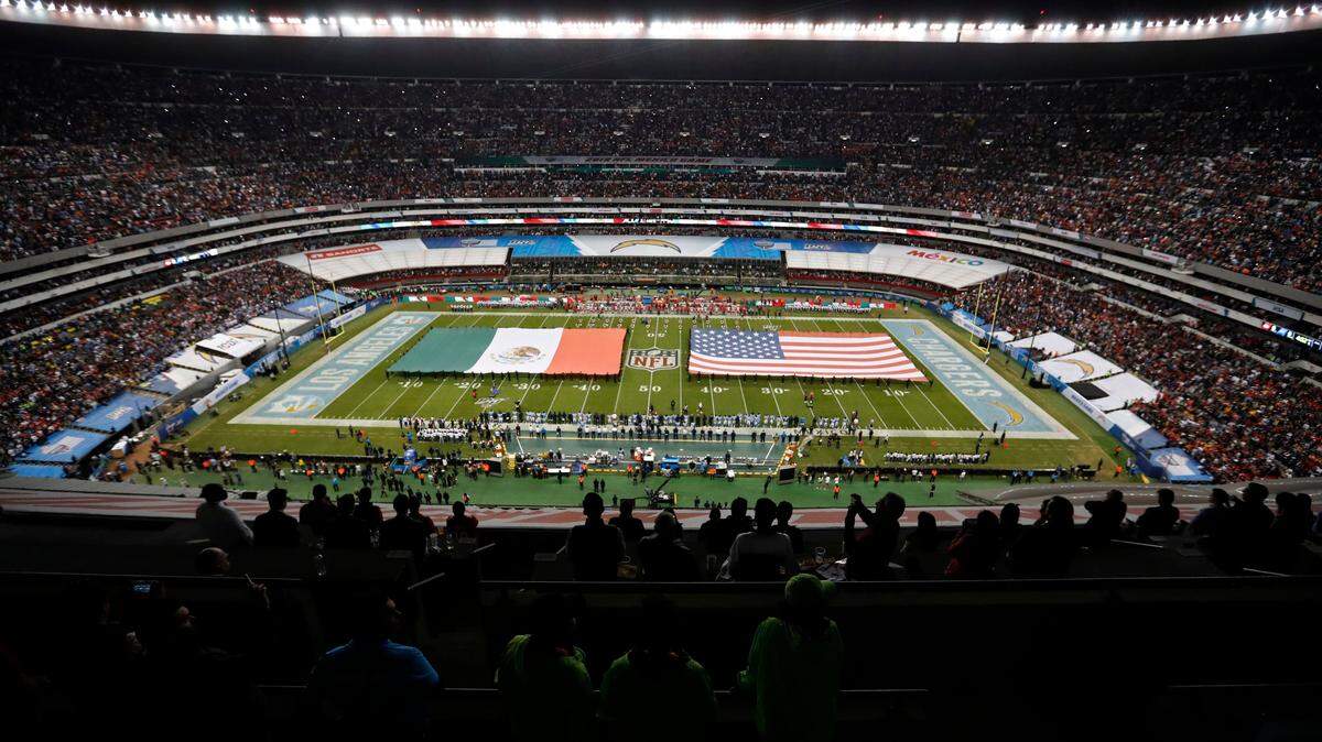 The flags of Mexico and the United States cover the field before Monday night’s Chiefs-Chargers game in Mexico City.