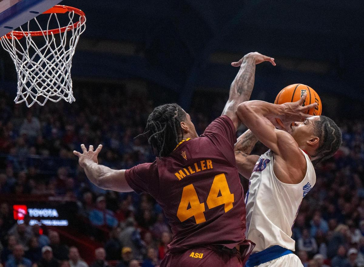 Kansas Jayhawks guard Shakeel Moore (No. 0, at right) goes up for a shot against the defense of Arizona State Sun Devils guard Adam Miller during a college basketball game at Allen Fieldhouse in Lawrence, Kansas, on Wednesday, Jan. 8, 2025.