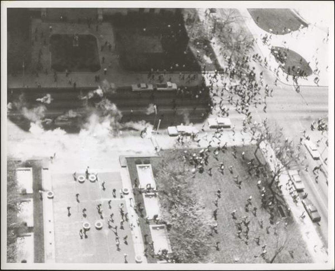 Crowd runs away from City Hall to escape tear gas cloud.