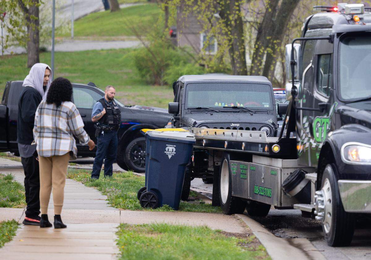 Police and family members of a woman who was shot in a south Kansas City neighborhood in early April 2025 look on as a Jeep was towed from the scene.