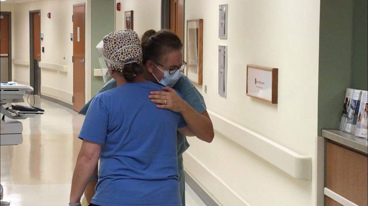 Mercy Hospital nurse Tracy Hill, right, hugged another staffer at the Springfield hospital after losing a COVID-19 patient in November.