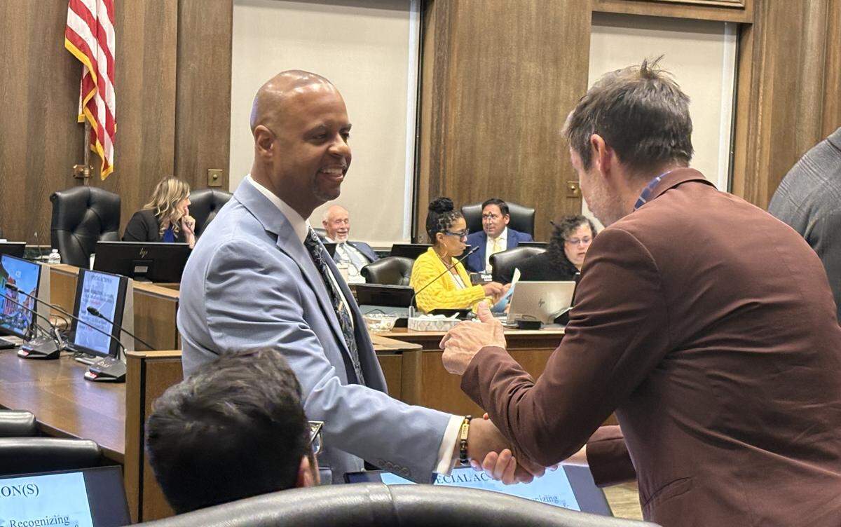 Public Works Director Michael Shaw shakes hands with Councilmember Eric Bunch during a City Council meeting on May 21, 2026.