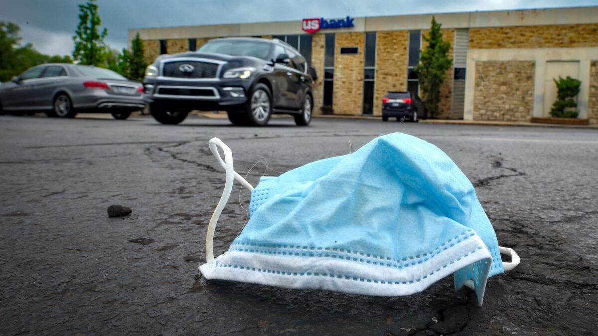A discarded mask rests in the parking lot outside of the U.S. Bank in the Prairie Village Shopping Center.