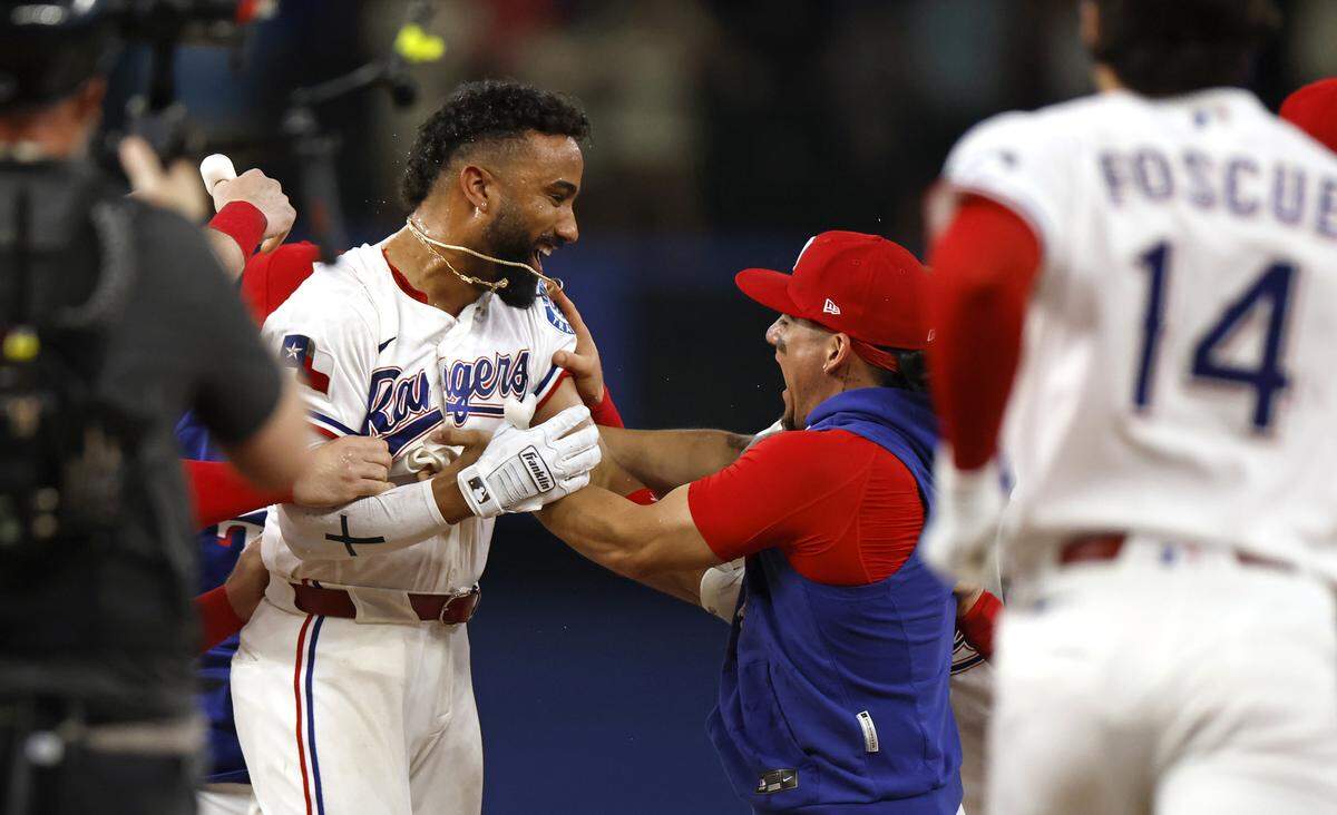 Ezequiel Duran #20 of the Texas Rangers celebrates with teammates after hitting a walk off single to win the game against the Kansas City Royals at Globe Life Field on May 30, 2026 in Arlington, Texas.