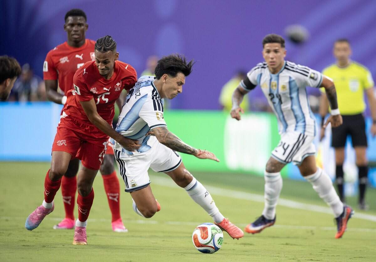 Argentina defender Lisandro Martínez (6) is pulled to the ground by Switzerland midfielder Djibril Sow (15) during the FIFA World Cup quarterfinal match at Kansas City (Arrowhead) Stadium in Kansas City on Saturday, July 11, 2026.