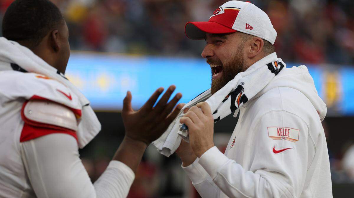 Chiefs tight end Travis Kelce (right) shares a laugh with teammates on the sideline during Sunday’s game against the Los Angeles Chargers at SoFi Stadium.