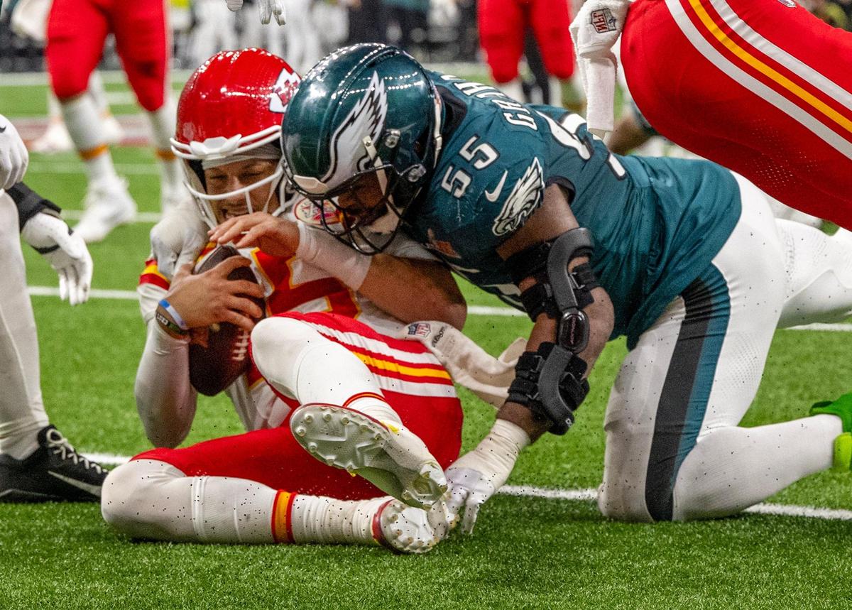 Kansas City Chiefs quarterback Patrick Mahomes (15) slides and his tackled by Philadelphia Eagles defensive end Brandon Graham (55) in Super Bowl LIX on Sunday, Feb. 9, 2025, in New Orleans.
