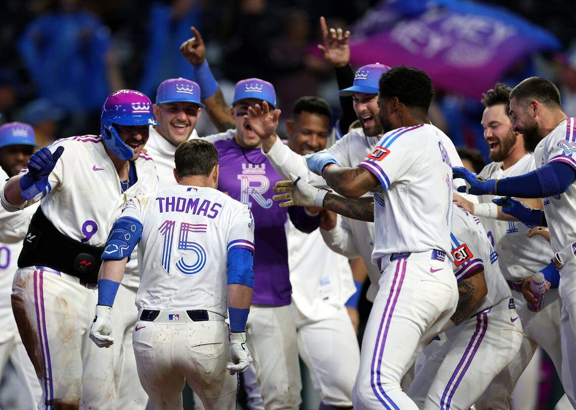 Lane Thomas #15 of the Kansas City Royals is congratulated by teammates at home plate after hitting a walk-off game-winning home run during the bottom of the 10th inning of the game against the Los Angeles Angels at Kauffman Stadium on April 26, 2026 in Kansas City.