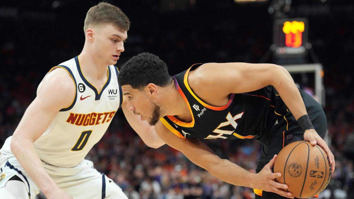 Denver Nuggets guard Christian Braun (0) guards Phoenix Suns All-Star Devin Booker (1) during the first half of Game 6 of the 2023 Western Conference Semifinals at Footprint Center on May 11, 2023.