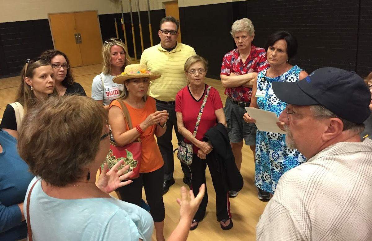 Upset citizens surrounded Park Hill Superintendent Jeanette Cowherd (second from right) at a community meeting at the Plaza Middle School gymnasium in July. They had concerns about the district’s plans to build new schools, which include destroying parts of the Line Creek Forest.