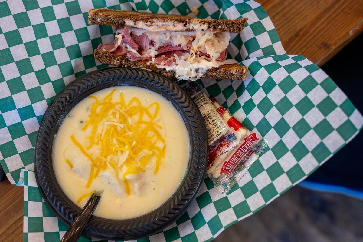 A half order Browne’s Reuben sandwich, featuring Irish corned beef, Swiss cheese, sauerkraut, housemade Thousand Island, and horseradish dressing, toasted marble rye accompanied by Irish potato soup is served at Browne’s Irish Marketplace.
