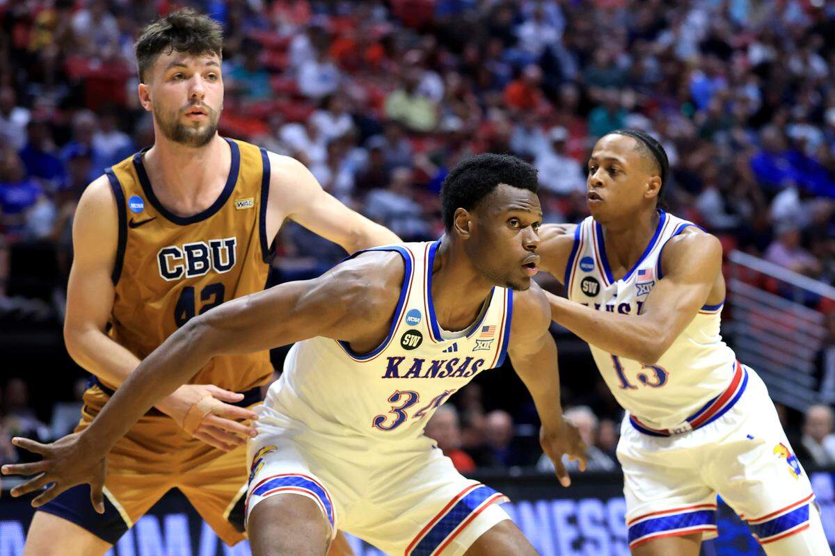 Paul Mbiya #34 and Elmarko Jackson #13 of the Kansas Jayhawks box out Bradey Henige #42 of the California Baptist Lancers during the first round of the 2026 NCAA Men's Basketball Tournament at Viejas Arena at San Diego State University on March 20, 2026 in San Diego.