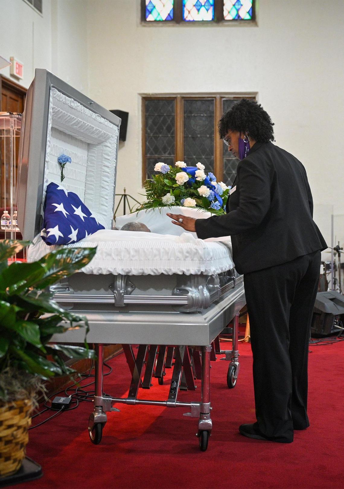 Gwendelrae Hicks, owner of Northern Star Mortuary, checks the casket before the funeral of Charles Watkins at Paseo Baptist Church in Kansas City.