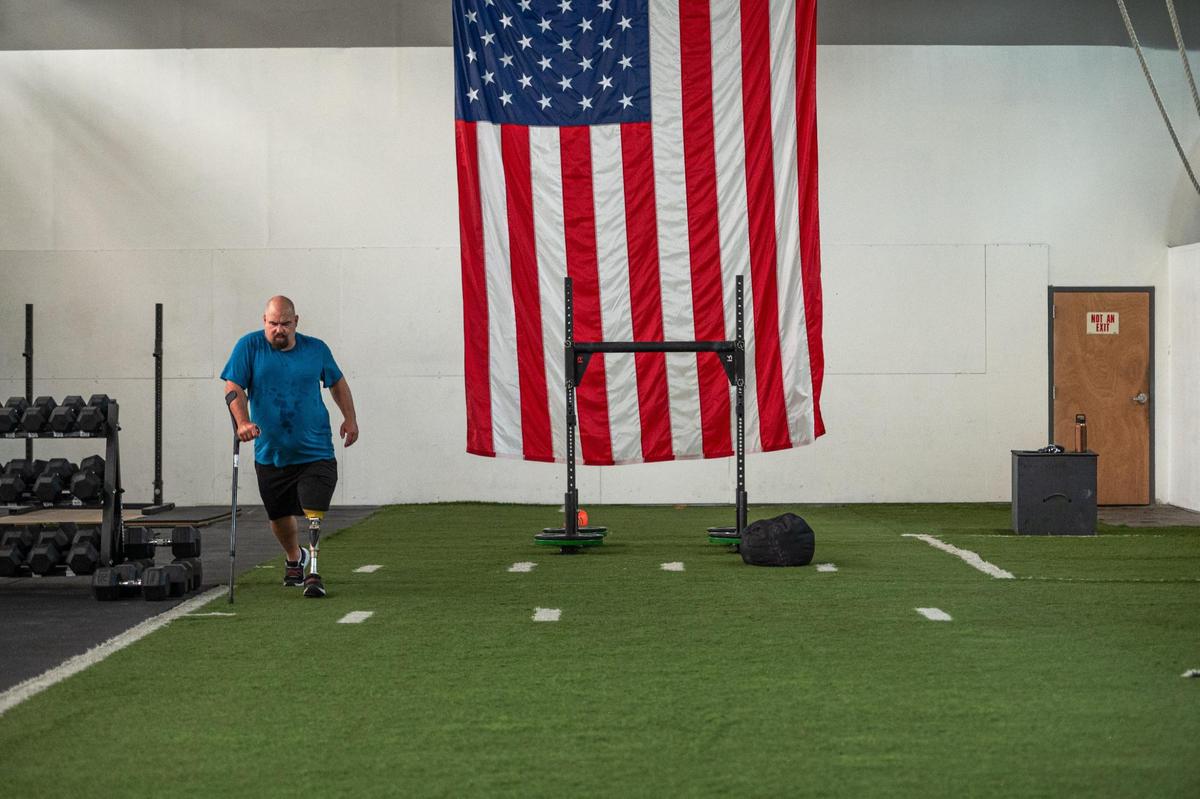 Daniel Bufford walks along a turf field during his work out Brave Enough CrossFit. Bufford is learning to walk again after losing his left leg in a motorcycle accident in September 2022.