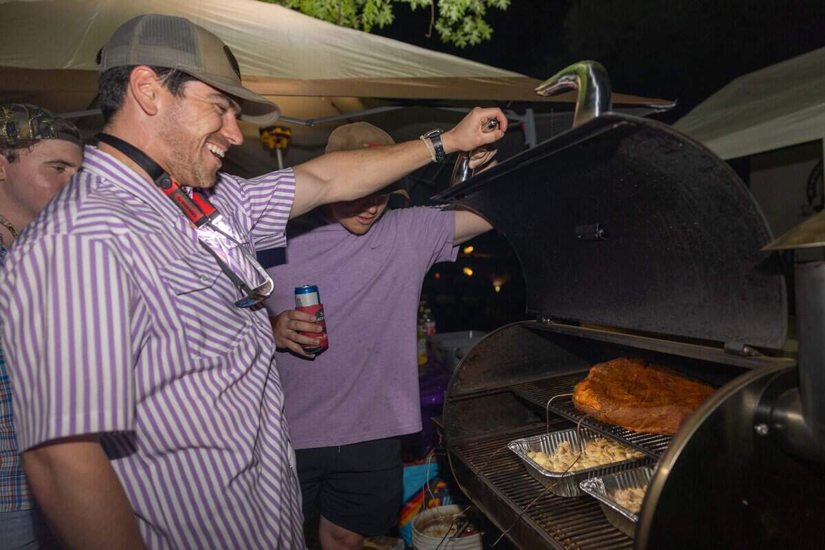 Nate Meysenburg lifts the lid of the smoker to check on their teams brisket at The Great Lenexa BBQ Battle on Friday, June 26, 2026.