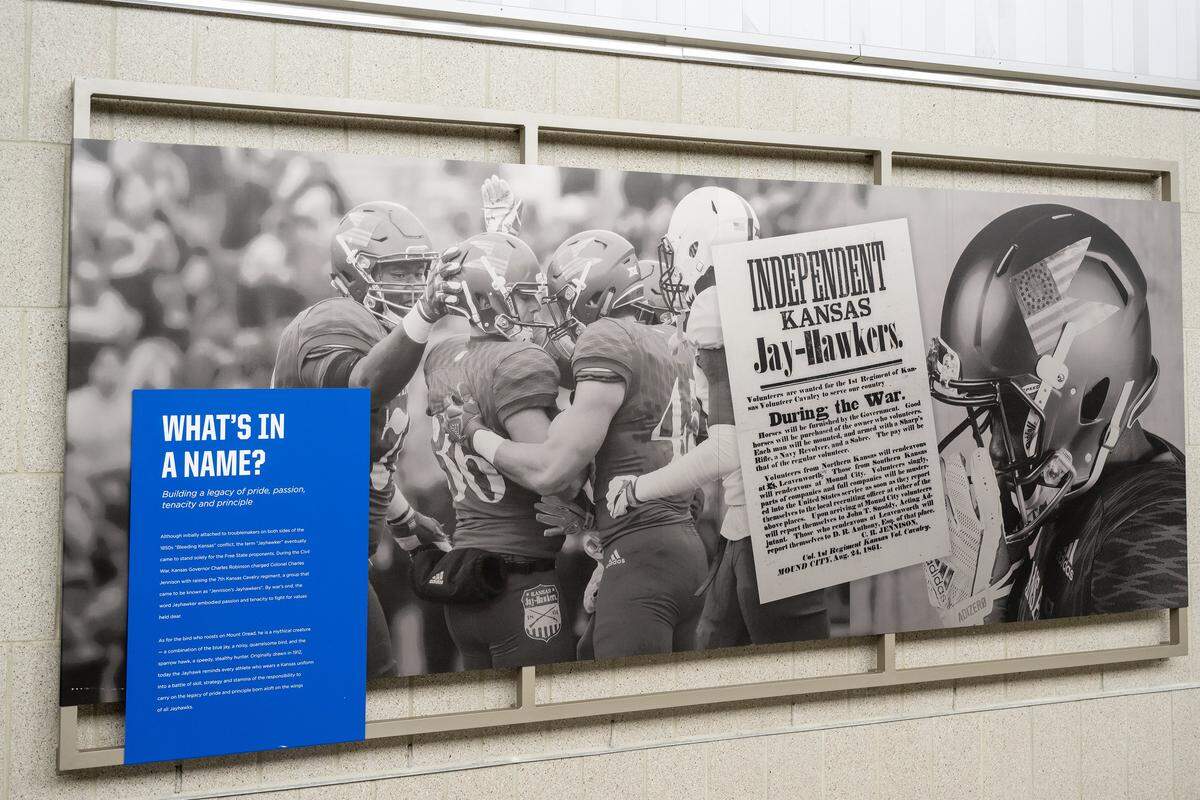 A display explaining the name ‘Jayhawks’ hangs in a concourse at the newly renovated David Booth Kansas Memorial Stadium.