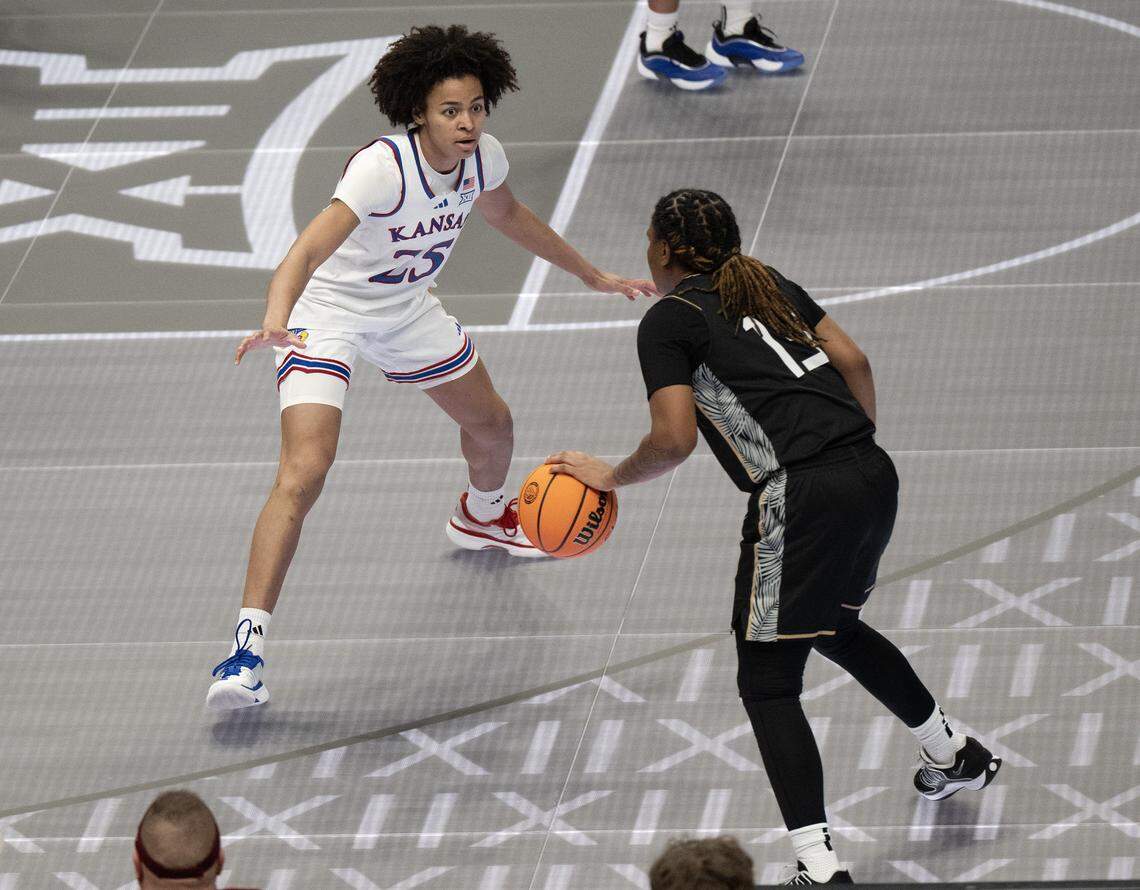UCF Knights guard Summer Yancy (13) shields the ball from Kansas Jayhawks forward Jaliya Davis (25) during the first quarter of the Big 12 Women's Basketball Tournament at T-Mobile Center on Wednesday, March 4, 2026, in Kansas City.