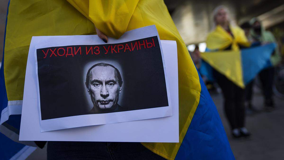 A demonstrator holds a picture of Russian President Vladimir Putin during a pro-Ukraine protest in Israel. Sign in Russian reads “get out of Ukraine”. File photo