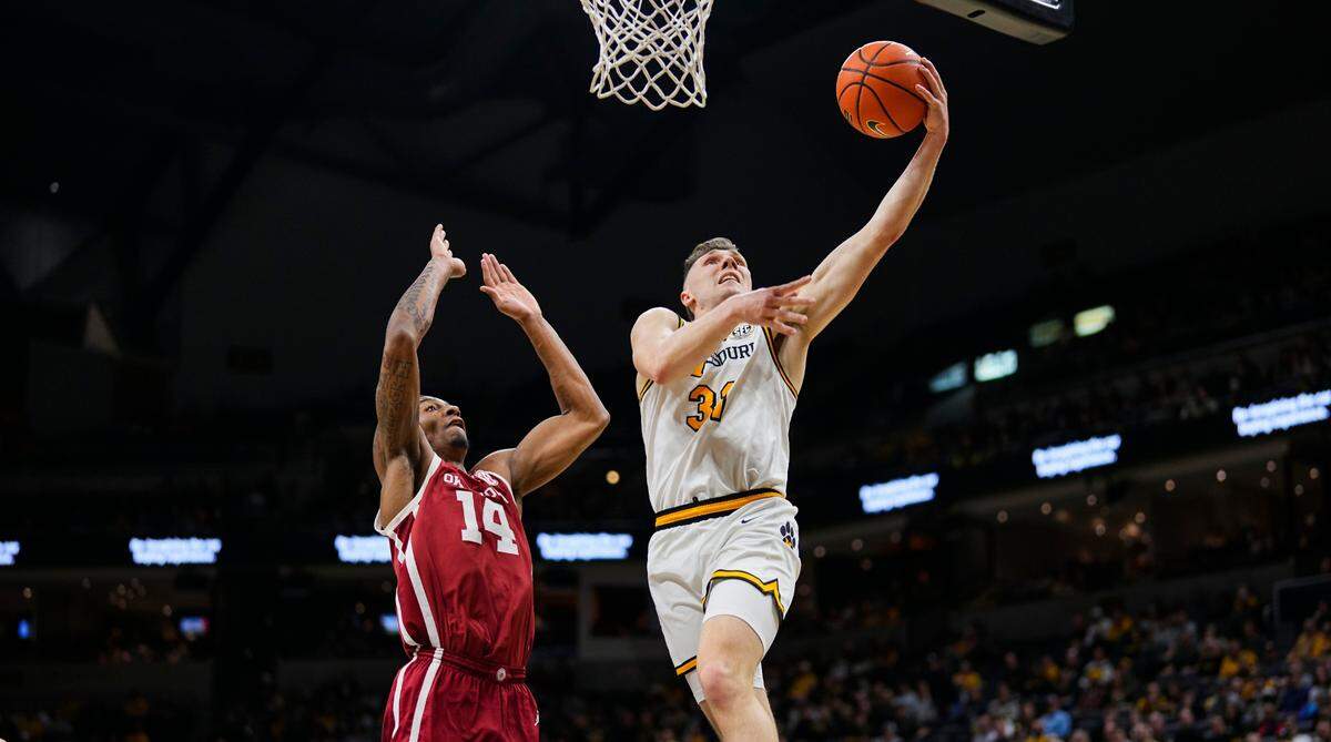 Missouri Tigers guard Caleb Grill, right, drives for a layup past Oklahoma Sooners forward Jalon Moore during an SEC men’s basketball game Mizzou Arena in Columbia on Wednesday, Feb. 12, 2025.