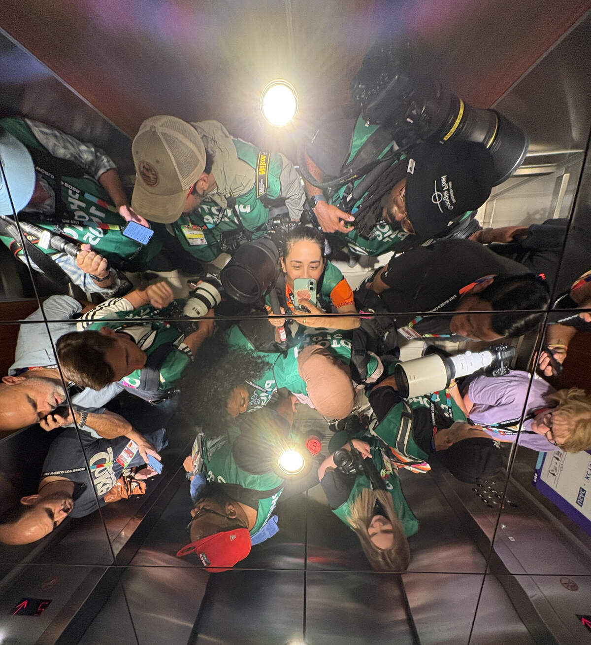 Photojournalist Emily Curiel, center, takes a selfie in an elevator as the reflections of fellow photojournalists are seen while on the way to the pitch before a FIFA World Cup group-stage soccer match between Algeria and Argentina at Kansas City (Arrowhead) Stadium on Tuesday, June 16, 2026, in Kansas City.