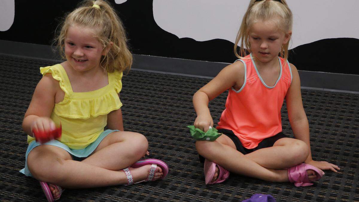 During the Olathe Public Library’s recent kids program, “Got Rhythm?”, 5-year-old Darby, left, and 7-year-old Lucy learned and played the fast-paced African musical game, “Obsiwana.”