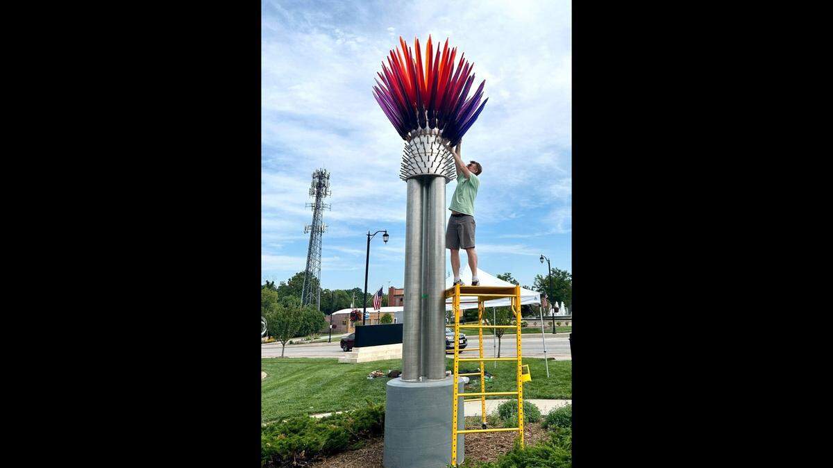 Artist Tyler Kimball installs “Prairie Paintbrush” outside the Olathe Downtown Library.