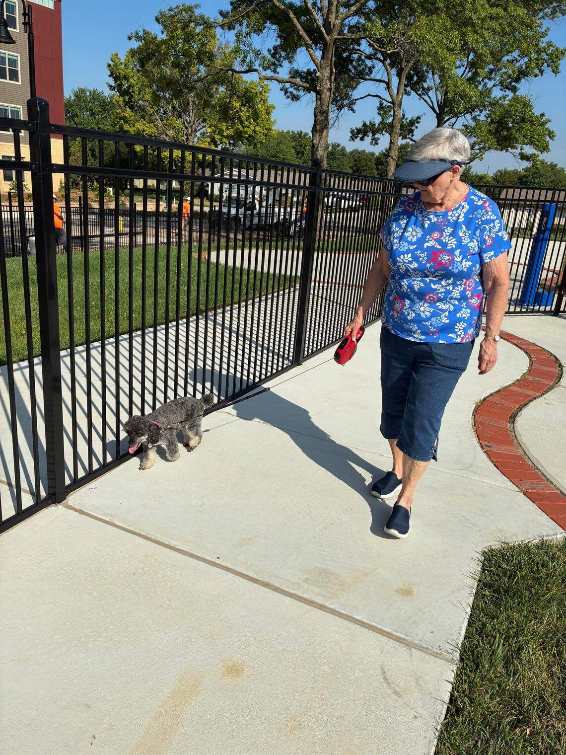 Bonnie Berkihiser walks her dog, Fonzie, in the dog park at John Knox Village in Lee’s Summit. Fonzie is an 8-year-old poodle.